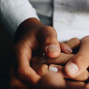 Close up of intertwined hands, symbolizing unity, support, and connection.